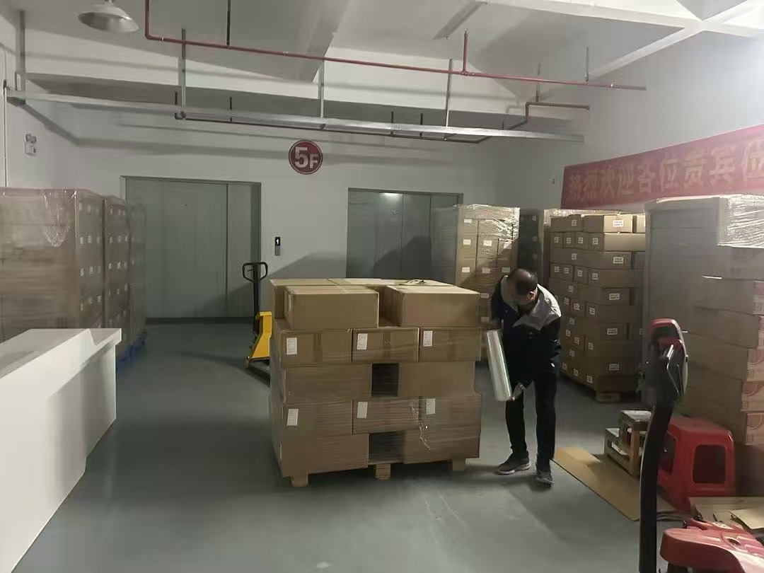 Worker wrapping cartons on a pallet in the packing area
